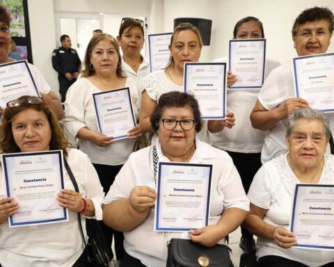 Mujeres mostrando su constancia de participaron.