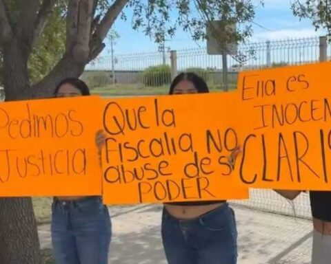 Mujeres manifestándose sosteniendo cartulinas.