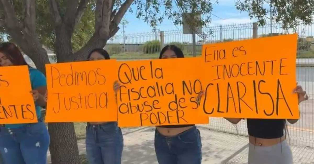 Mujeres manifestándose sosteniendo cartulinas.