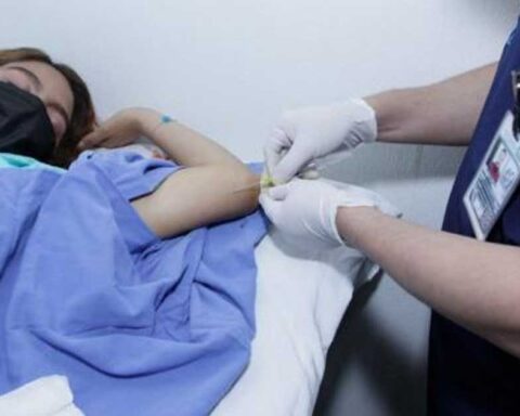 Enfermero colocando el implante anticonceptivo en el brazo de una mujer.