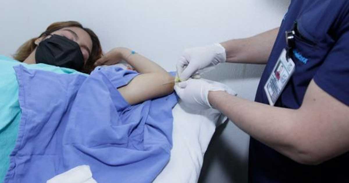 Enfermero colocando el implante anticonceptivo en el brazo de una mujer.