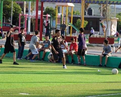 Jóvenes jugando futbol en la cancha.
