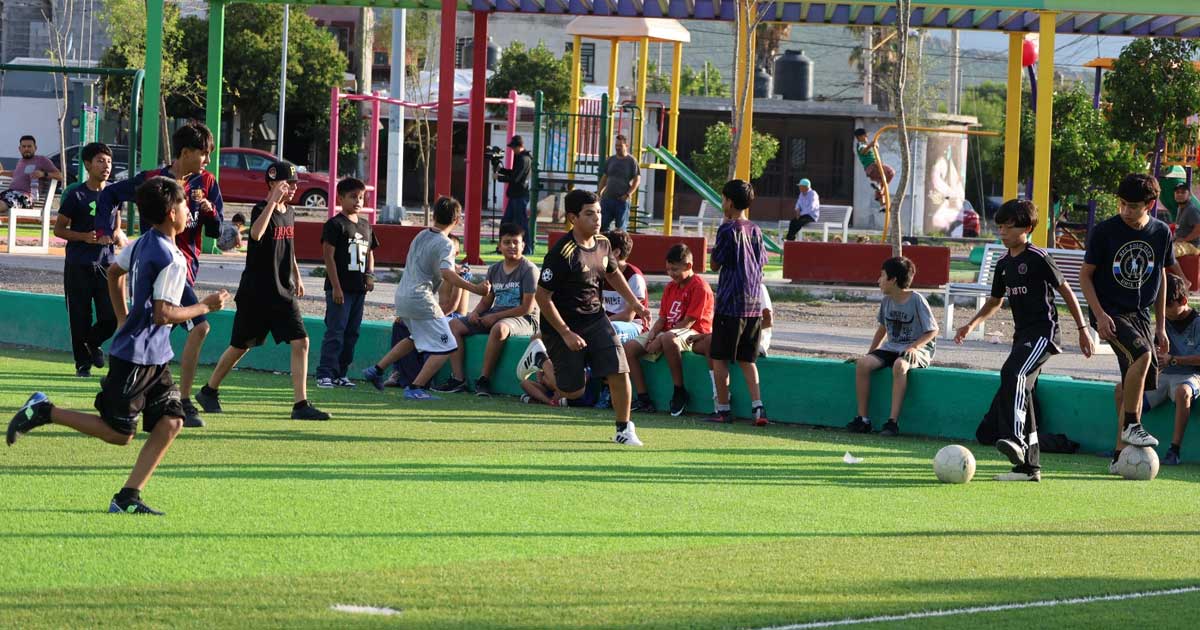 Jóvenes jugando futbol en la cancha.