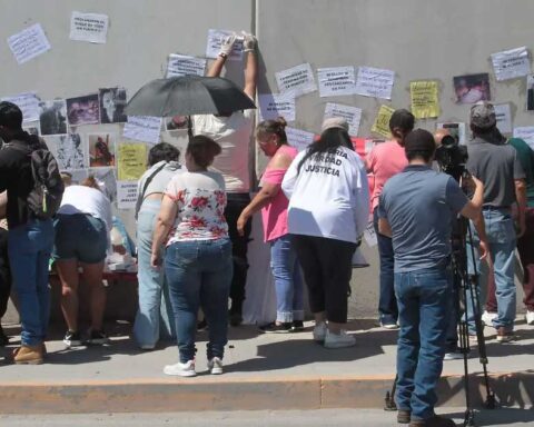 Personas protestando y pegando pancartas.