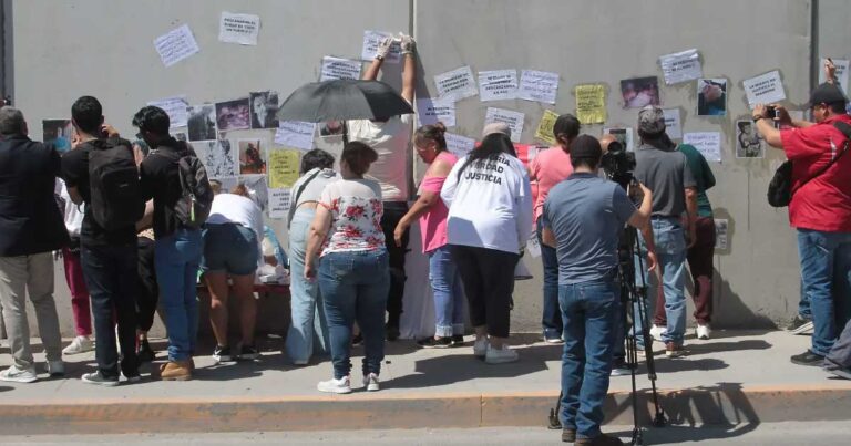 Personas protestando y pegando pancartas.