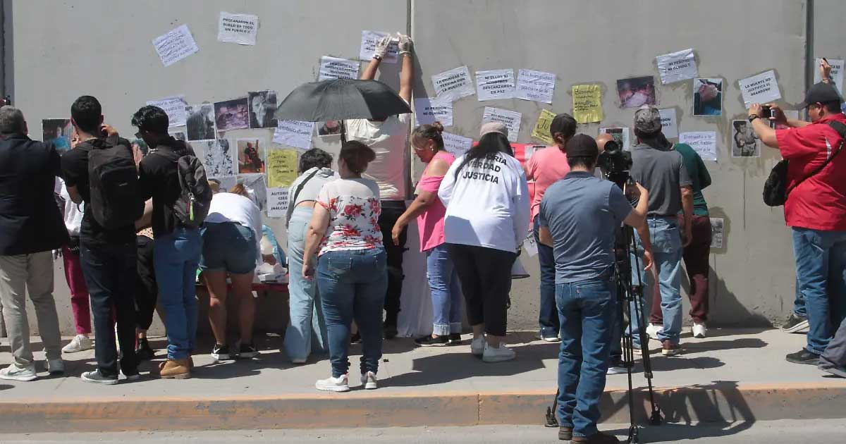 Personas protestando y pegando pancartas.