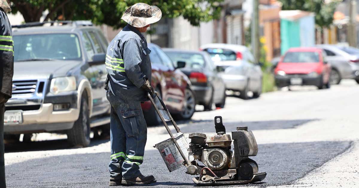 Hombre con máquina reparando un bache.