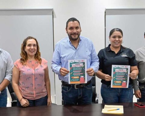 Alcalde y funcionarios sosteniendo un cartel con la publicidad de la feria.