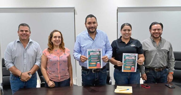 Alcalde y funcionarios sosteniendo un cartel con la publicidad de la feria.