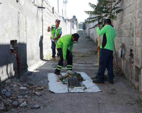 Trabajadores limpiando un callejón.