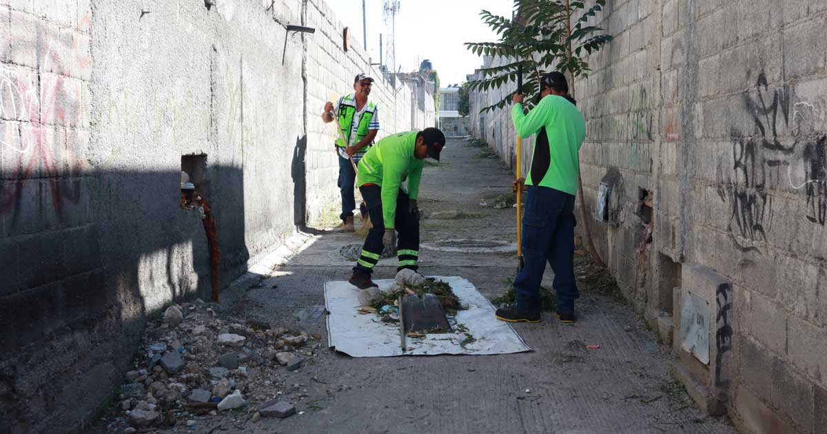 Trabajadores limpiando un callejón.