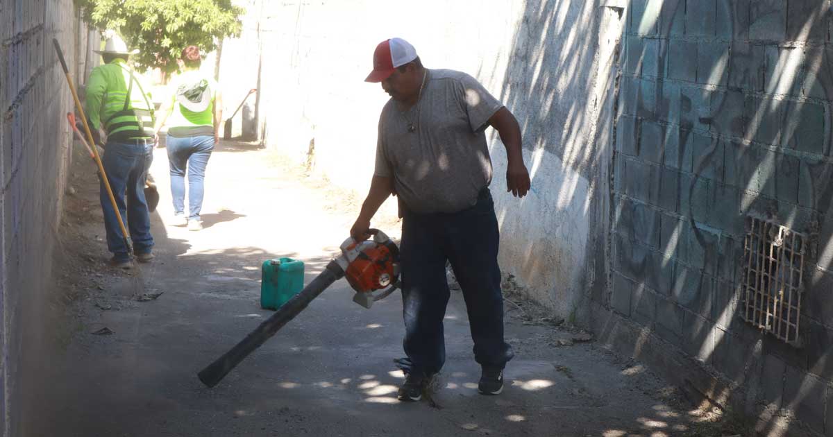 Trabajadores limpiando un callejón.