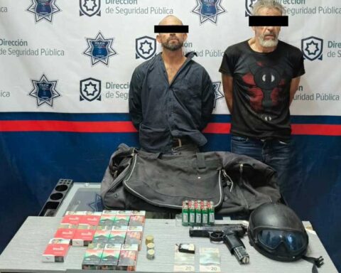 Los dos hombres detenidos con los objetos que llevaban.