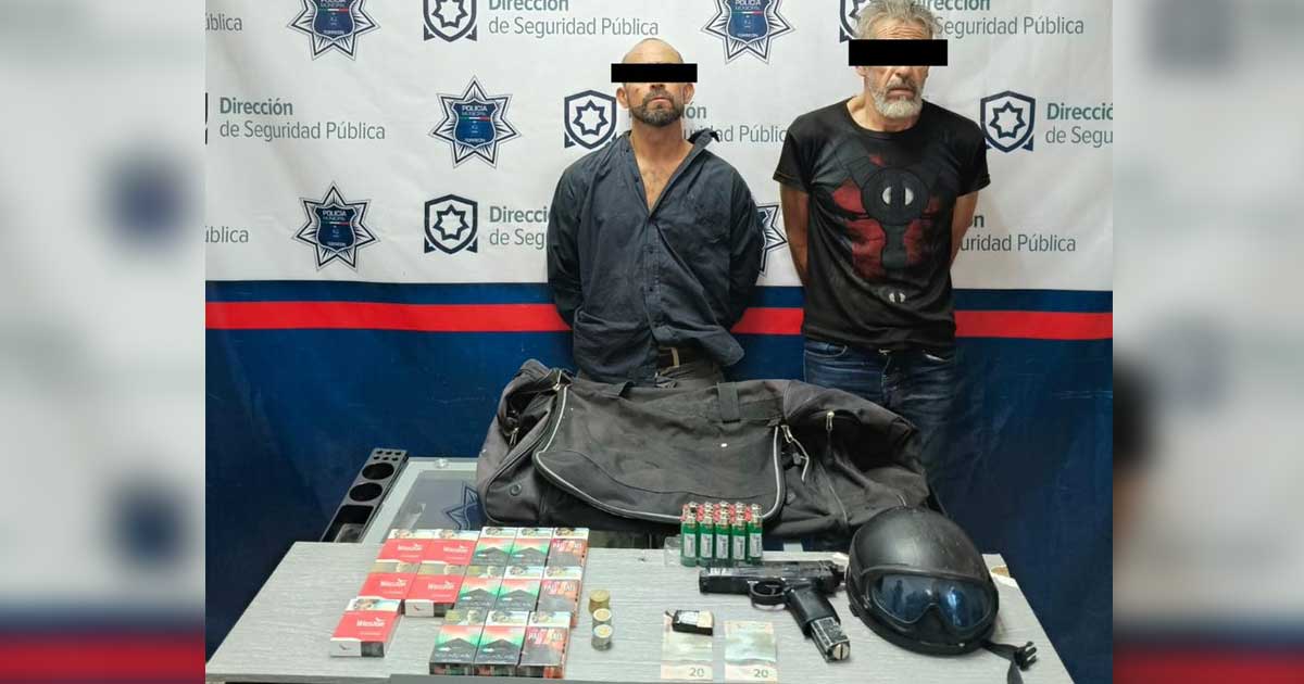 Los dos hombres detenidos con los objetos que llevaban.