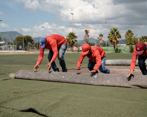 Hombres remplazando el pasto sintético.
