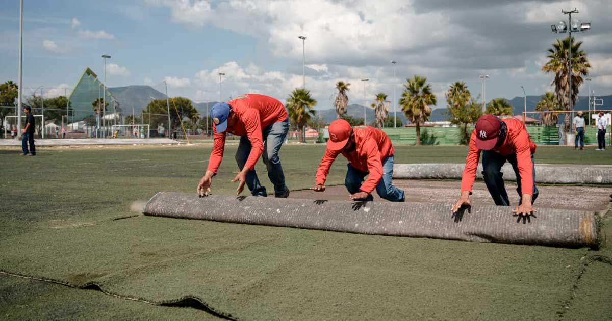 Hombres remplazando el pasto sintético.