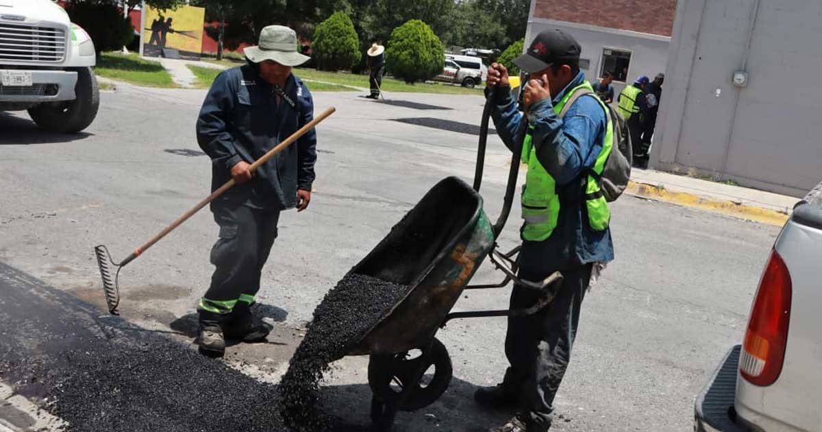 Hombres reparando baches en Saltillo.