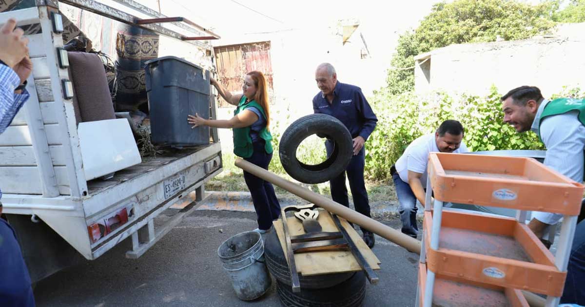Funcionarios subiendo cacharros a una camioneta.