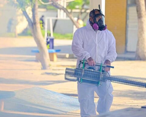 Trabajador fumigando dentro de una escuela.
