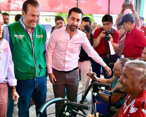 Funcionarios entregando sillas de ruedas.