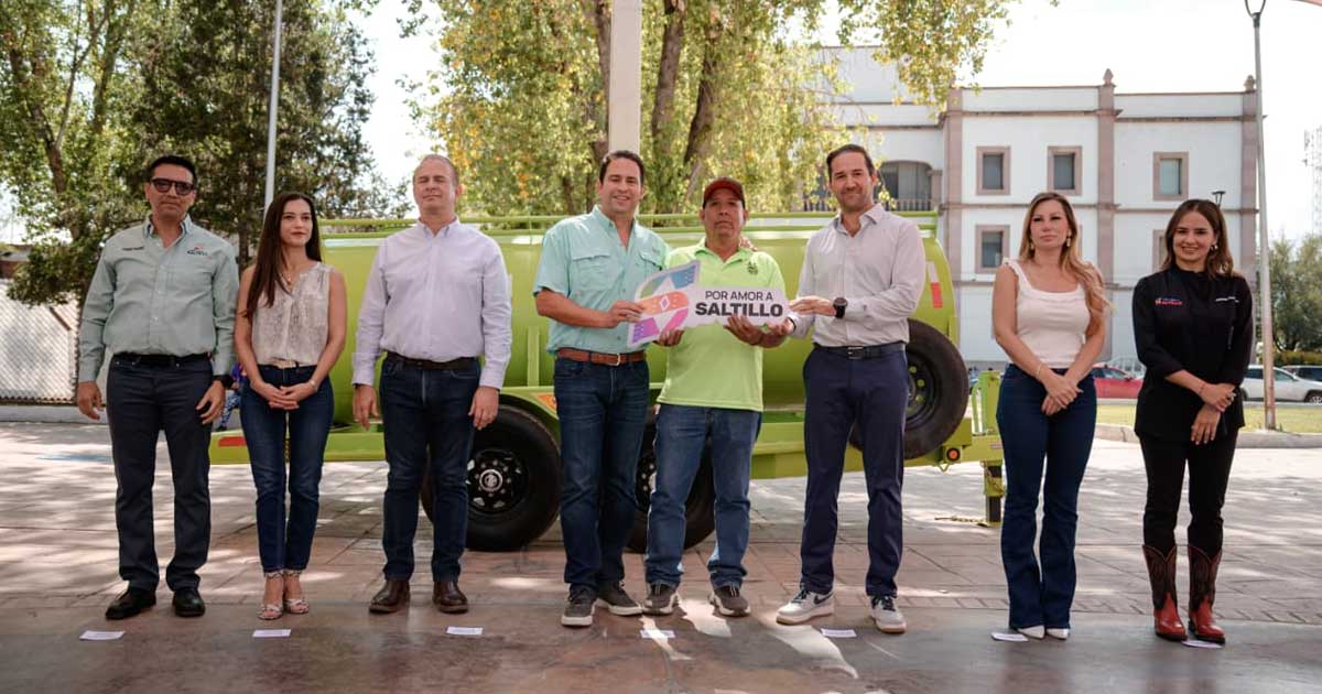 Funcionarios recibiendo una llave simbólica de la pipa donada.
