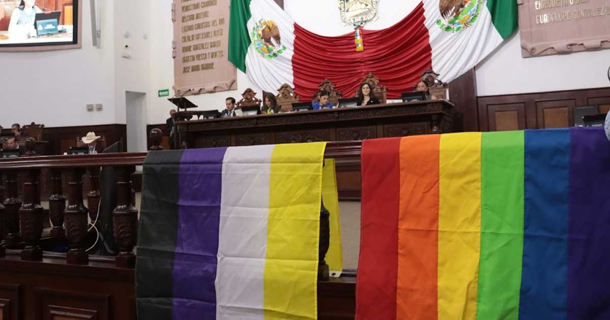 Interior del Congreso de Coahuila; banderas de comunidad LGBT+ en un barandal.