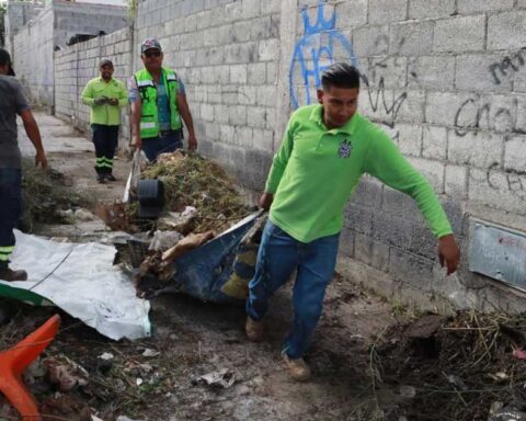 Trabajadores levantando escombro y basura de un callejón en Saltillo.