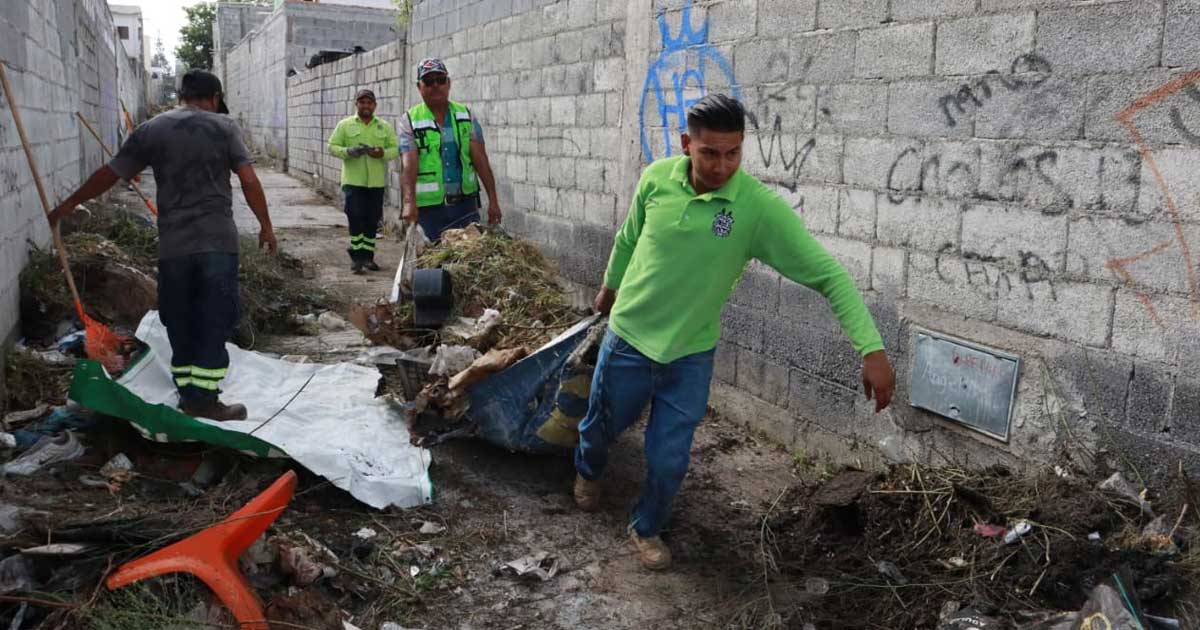 Trabajadores levantando escombro y basura de un callejón en Saltillo.