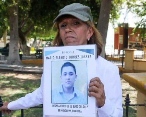 Sandra Lorena Torres Juárez sosteniendo la foto de su hijo Mario Alberto Torres, desaparecido desde 2012.