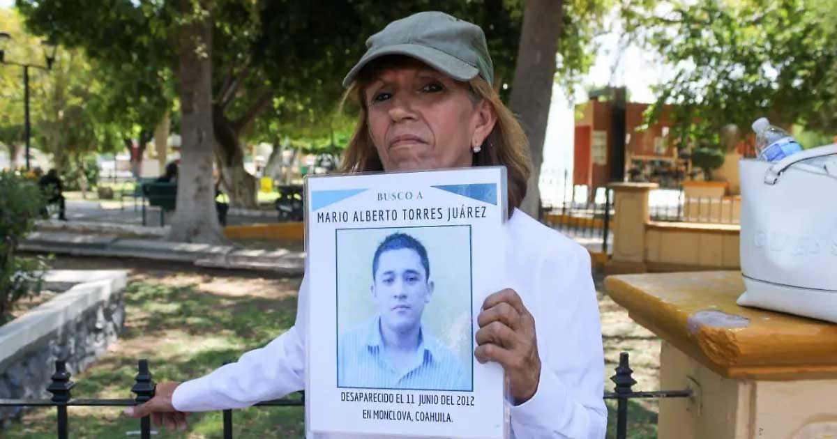 Sandra Lorena Torres Juárez sosteniendo la foto de su hijo Mario Alberto Torres, desaparecido desde 2012.