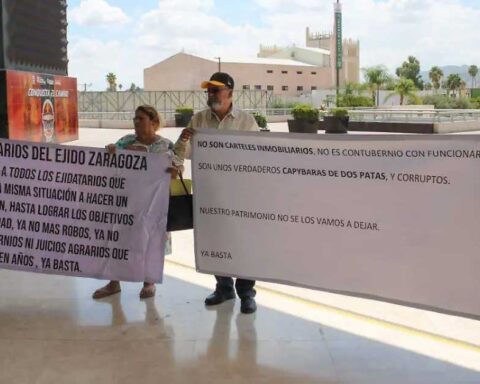 Ejidatarios sosteniendo lonas para protestar afuera de la presidencia de Torreón.