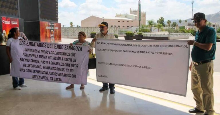 Ejidatarios sosteniendo lonas para protestar afuera de la presidencia de Torreón.