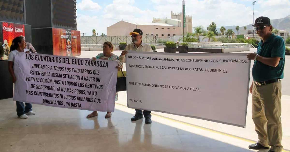 Ejidatarios sosteniendo lonas para protestar afuera de la presidencia de Torreón.