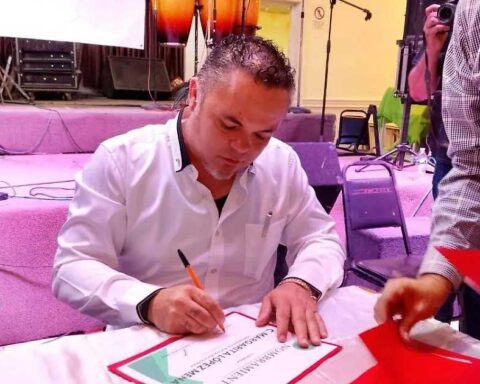 Carlos Muñoz, nuevo líder de la UNTA, firmando un documento en una mesa.