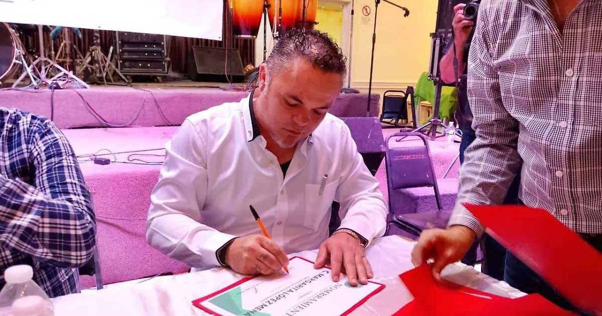 Carlos Muñoz, nuevo líder de la UNTA, firmando un documento en una mesa.
