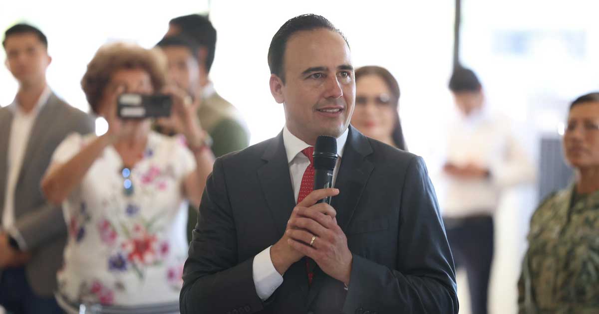 El gobernador de Coahuila Manolo Jiménez sosteniendo un micrófono.