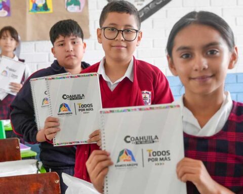 Niños de la primaria mostrando sus útiles escolares.