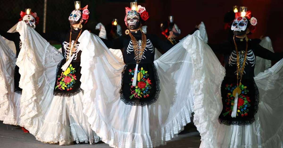 Mujeres bailando caracterizadas de catrina.