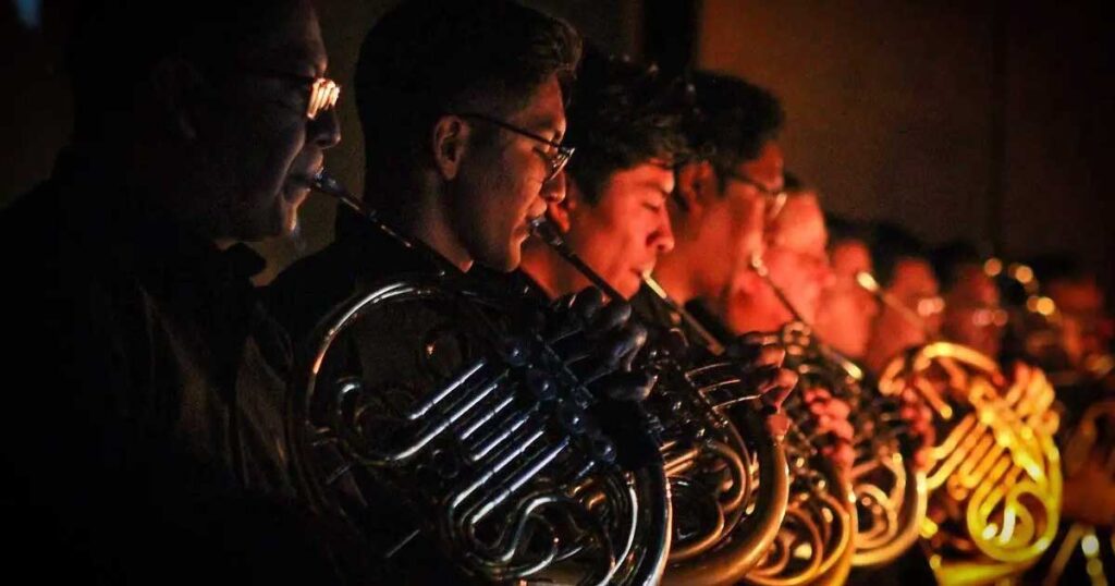 Integrantes de la Camerata de Coahuila tocando instrumentos.