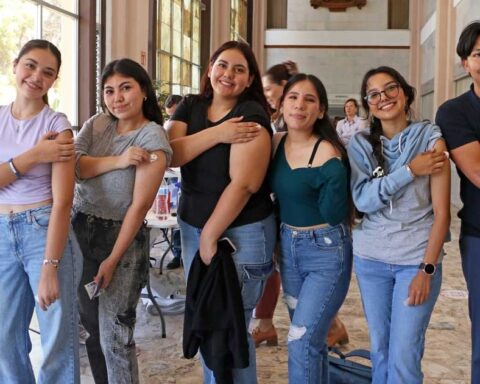 Jóvenes mostrando su brazo vacunado en la UAdeC.
