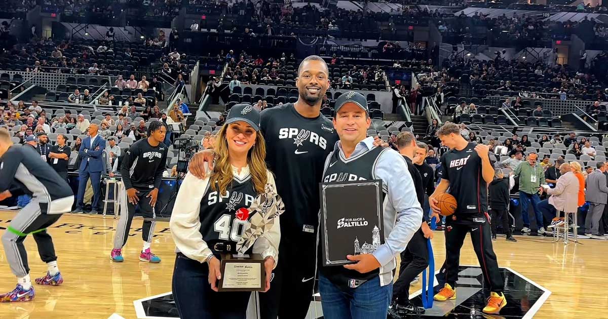 Luly López, Harrison Barnes y el alcalde Javier Díaz en la duela de una cancha de basquetbol en San Antonio.