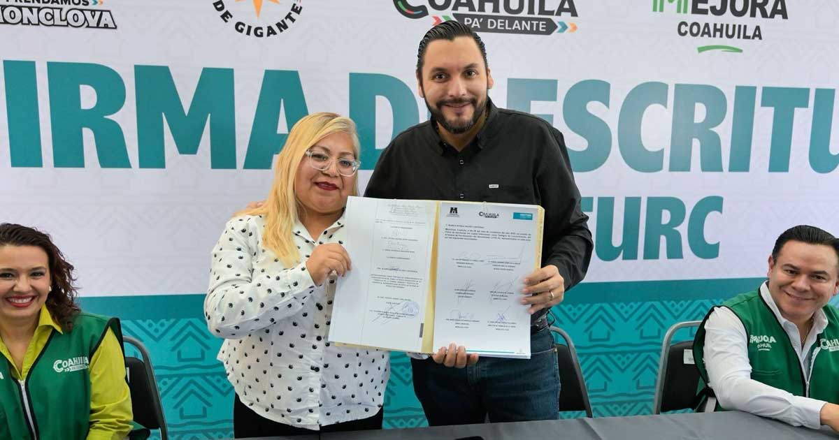 El alcalde Carlos Villarreal entregando una escritura.