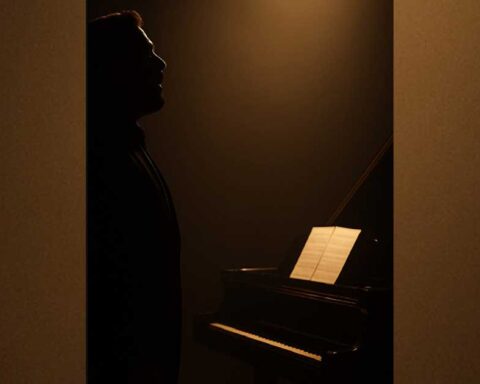 Silueta de un hombre frente a un piano.