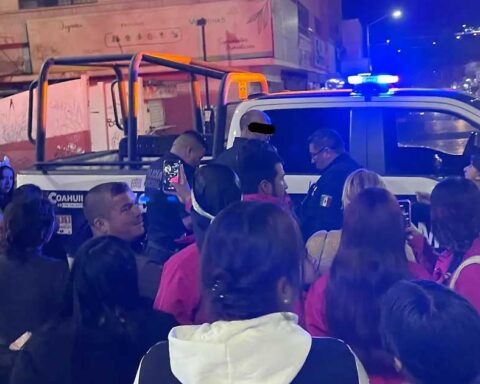 Hombre detenido siendo subido a la patrulla en medio de una multitud.