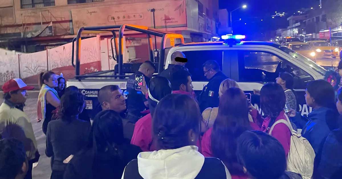 Hombre detenido siendo subido a la patrulla en medio de una multitud.
