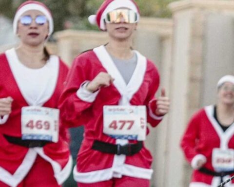 Mujeres vestidas de Santa Claus participando en la carrera.