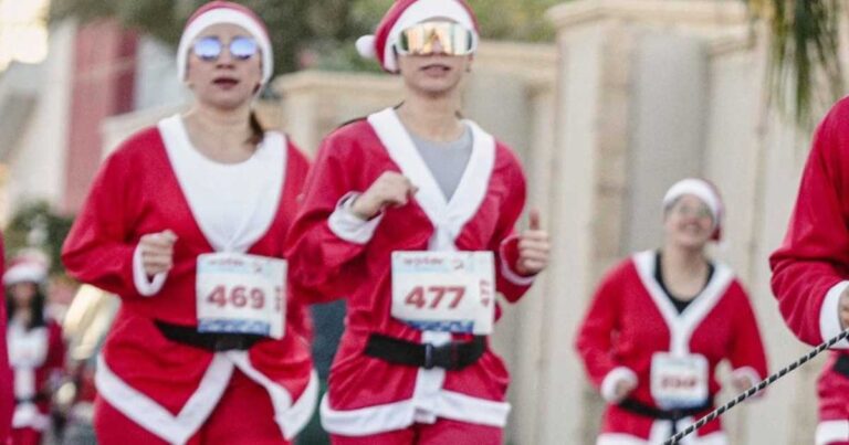 Mujeres vestidas de Santa Claus participando en la carrera.