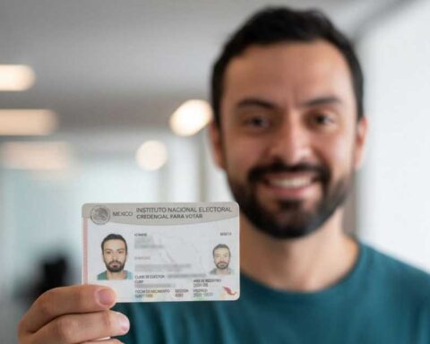 Hombre sosteniendo su credencial de elector.