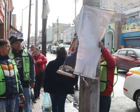 Trabajadores retirando anuncios en Saltillo.