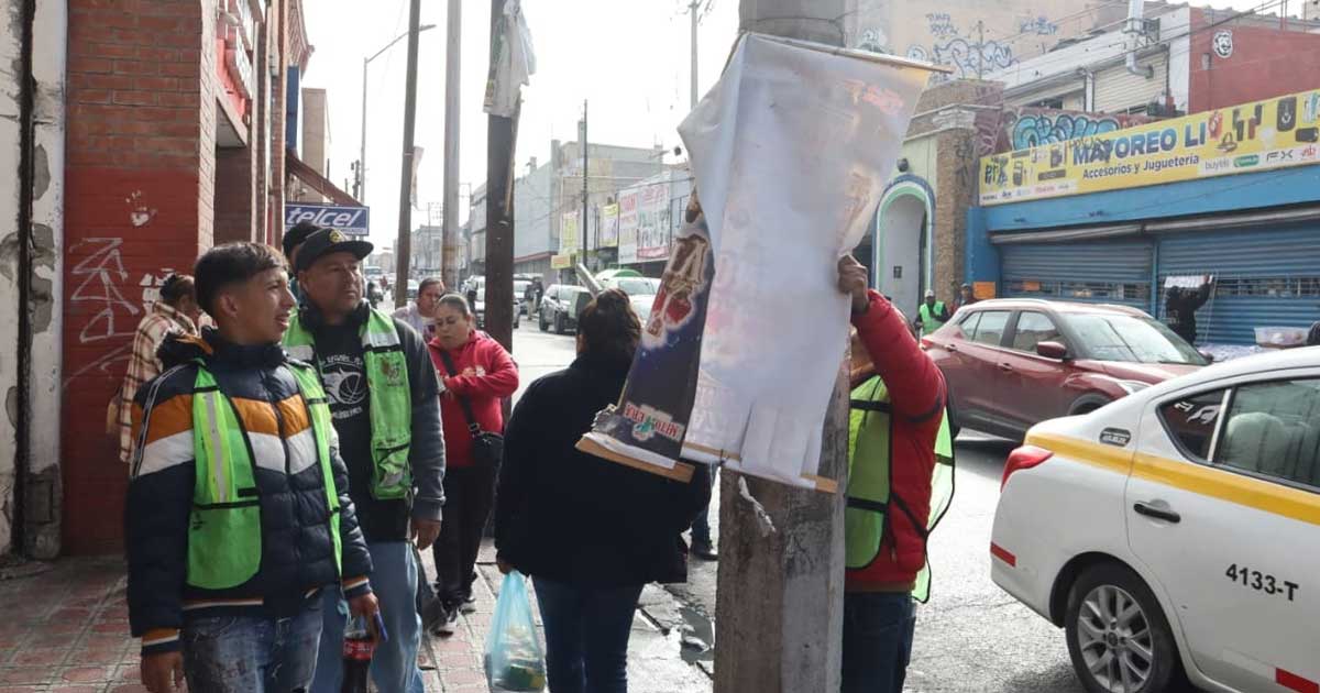Trabajadores retirando anuncios en Saltillo.